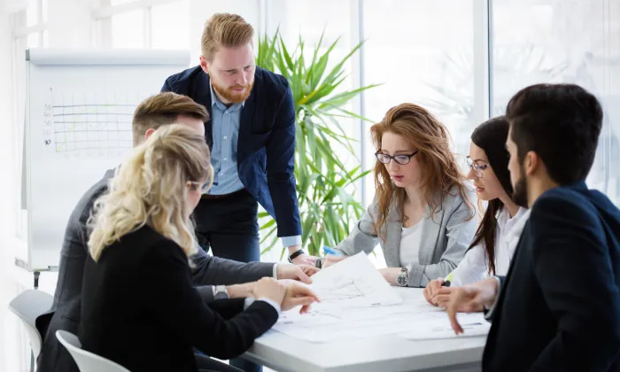 Engineering project team reviewing project plans and technical documents during a meeting.