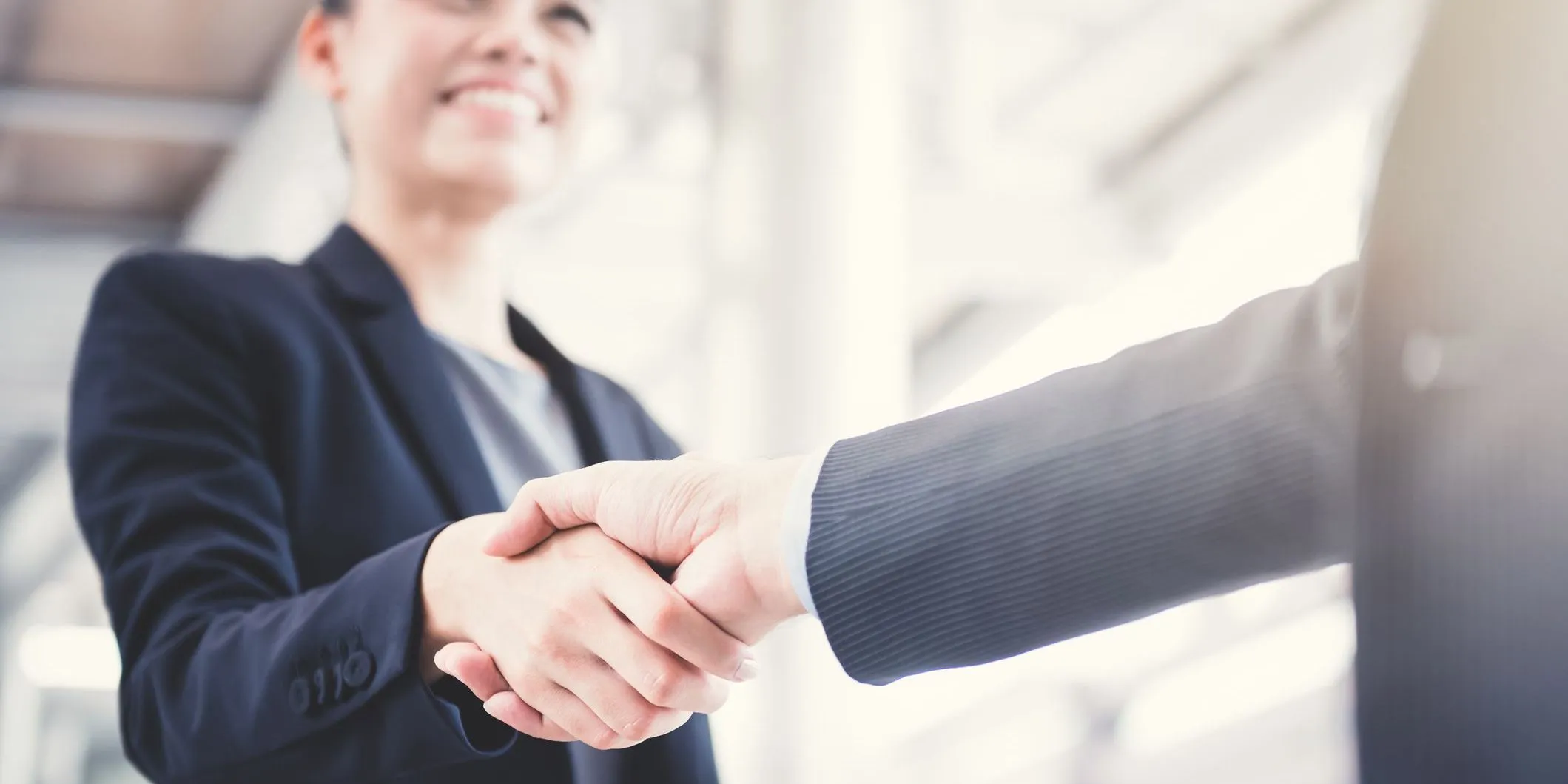 Two business professionals shaking hands after a successful agreement.