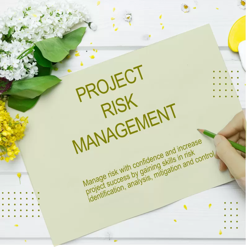 Text on light-green paper on a white background, next to beautiful spring flowers, about the project risk management training